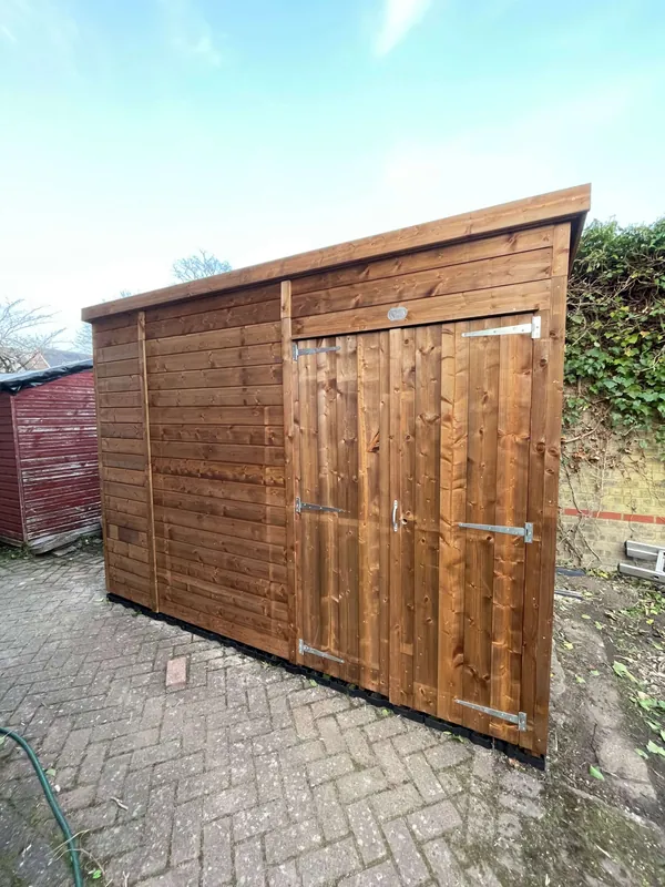 Timber pent shed built on block paving